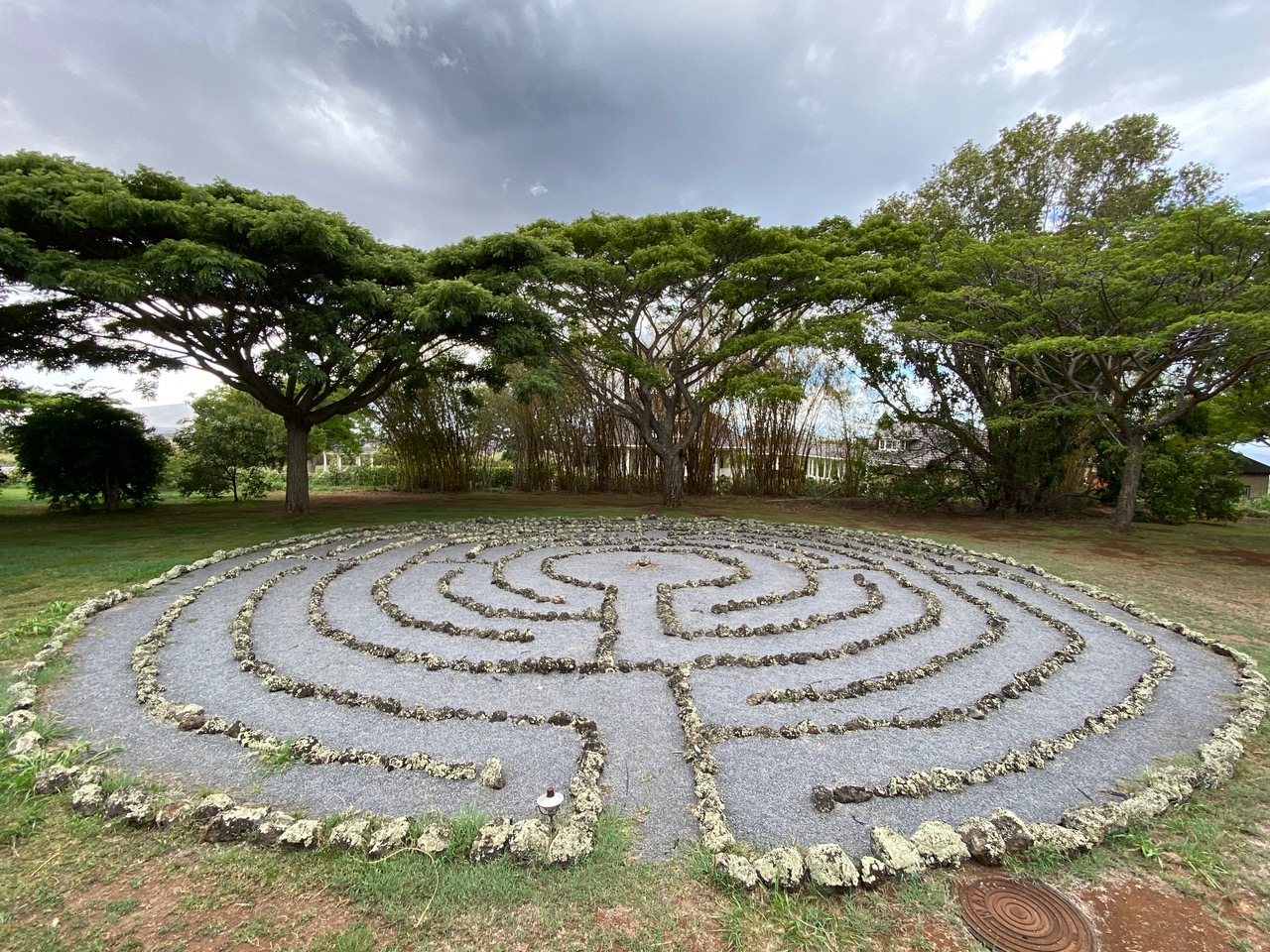 Stone labyrinth beneath monkeypod trees on Maui